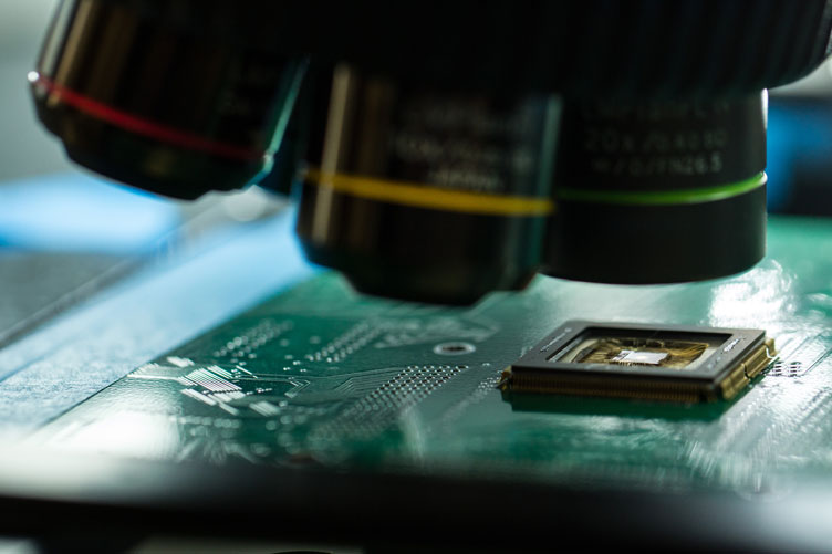 Close-up of complex microchip under a microscope