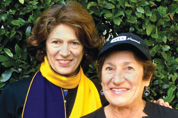 Rita and Marcie Rothman pose in UCLA gear in front of greenery.