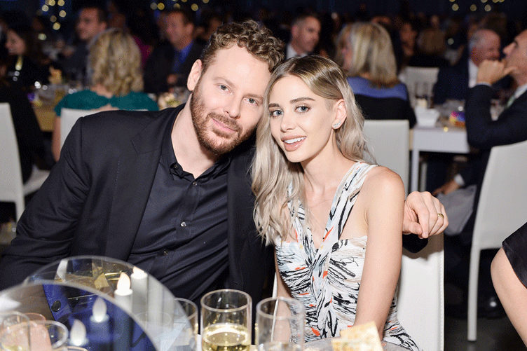 A couple poses at their table.