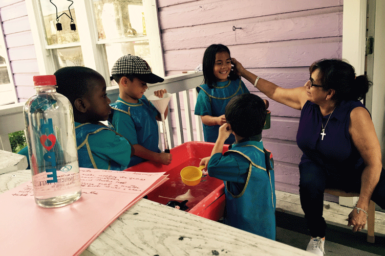 Older woman laughing with group of young kids on a porch