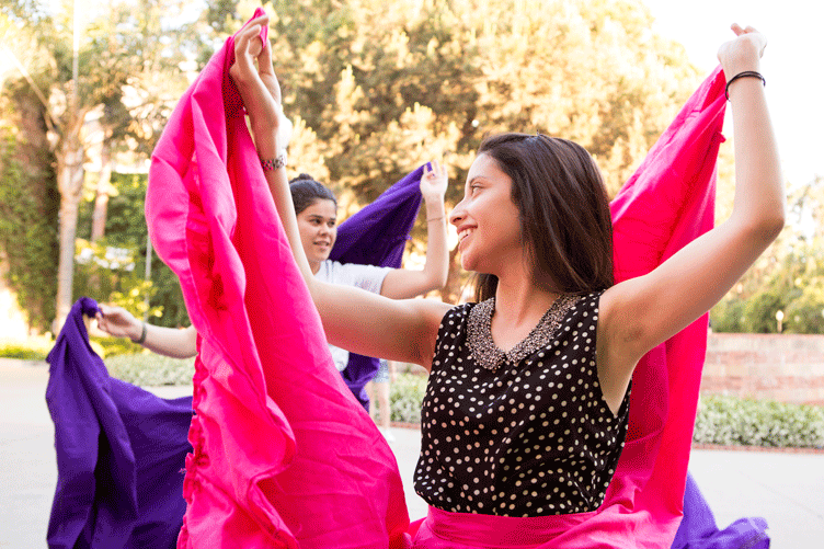 Two young women dance in flamenco skirts.