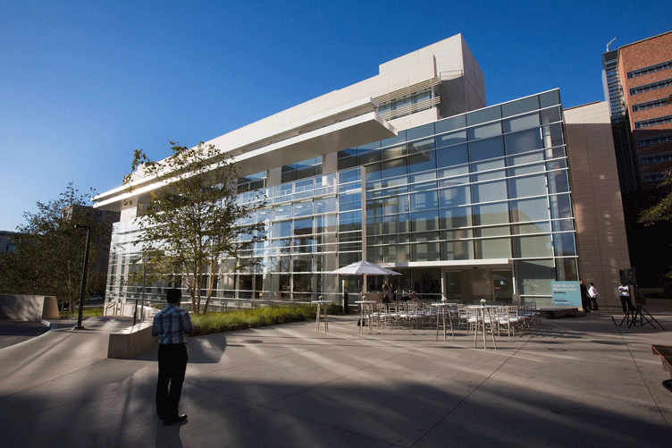 Exterior photograph of Edie & Lew Wasserman building, patio, trees and a man standing in the foreground